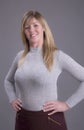 Woman with hands on waist wearing a tight jumper