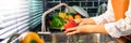 Woman hands washing Vegetables for Preparation of vegan salad on the worktop near to sink in a modern kitchen, Homemade healthy Royalty Free Stock Photo