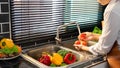 Woman hands washing Vegetables for Preparation of vegan salad on the worktop near to sink in a modern kitchen, Homemade healthy Royalty Free Stock Photo