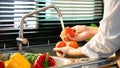 Woman hands washing Vegetables for Preparation of vegan salad on the worktop near to sink in a modern kitchen, Homemade healthy Royalty Free Stock Photo