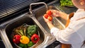 Woman hands washing Vegetables for Preparation of vegan salad on the worktop near to sink in a modern kitchen, Homemade healthy Royalty Free Stock Photo