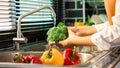 Woman hands washing Vegetables for Preparation of vegan salad on the worktop near to sink in a modern kitchen, Homemade healthy Royalty Free Stock Photo