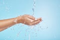 Woman hands, water splash and clean wellness, skincare and personal hygiene, health and shower on studio blue background Royalty Free Stock Photo