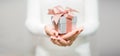 Woman hands with white sweater holding a small gift box for special event with copy space Royalty Free Stock Photo