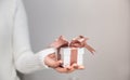 Woman hands with white sweater holding a small gift box for special event with copy space Royalty Free Stock Photo