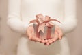 Woman hands with white sweater holding a small gift box for special event with copy space Royalty Free Stock Photo