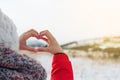 Woman hands in winter Heart shaped symbol of feelings and lifestyle concept with nature sunset light in the background. Royalty Free Stock Photo