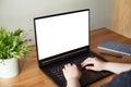 Woman hands working on laptop with blank white screen standing on the wooden office desk. Clipping path Royalty Free Stock Photo