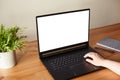 Woman hands working on laptop with blank white screen standing on the wooden office desk. Clipping path Royalty Free Stock Photo