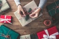 Woman hands wrapping christmas gifts on a wooden table