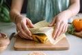 Woman hands wrapping a healthy sandwich in beeswax food wrap. Generative AI Royalty Free Stock Photo