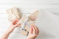 Woman hands are wrapping presents in a gift bag on white background, top view Royalty Free Stock Photo