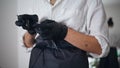 Woman hands wrapping tattoo machine at home. Girl putting disinfectant coating