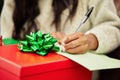 Woman, hands and writing on Christmas gift, note or letter in surprise, festive season or December holiday. Hand of