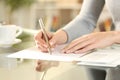 Woman hands writing a letter on a desk at home Royalty Free Stock Photo