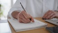 Woman hands writing in notebook wooden table closeup. Businesswoman making notes Royalty Free Stock Photo