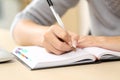 Woman hands writing notes on agenda on a desk Royalty Free Stock Photo