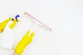 Woman hands with yellow rubber gloves holding window glass cleaning tool and spray bottle with detergent over white Royalty Free Stock Photo