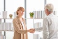 Woman handshaking greeting senior man client, Health visitor, and a senior man during a home visit Royalty Free Stock Photo