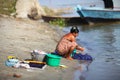 Woman handwashing clothes at the riverside in Myan