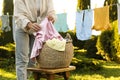 Woman hanging baby clothes with clothespins on washing line for drying in backyard, closeup Royalty Free Stock Photo