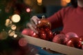 Woman hanging baubles on the Christmas tree