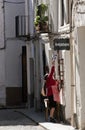 Woman hanging a ceramic plate on the door of a shop of antiques