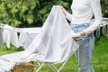 Woman hanging clean clothes on drying rack outside Royalty Free Stock Photo