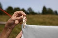 Woman hanging clean laundry with clothespin on washing line outdoors, closeup Royalty Free Stock Photo