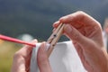 Woman hanging clean laundry with clothespin on washing line outdoors, closeup Royalty Free Stock Photo