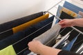 Woman hanging clean laundry on drying rack in bathroom