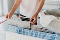 Woman hanging clean wet clothes laundry on drying rack at home laundry room Royalty Free Stock Photo