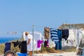 Woman hanging the clothes out to dry in the village of Oia on Santorini island