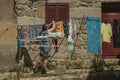 Woman hanging clothes to dry in front of old house