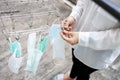 Woman is hanging dry the protective mask on round clothes hanger and clothespin in her hands,mask is drying,disinfecting masks