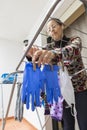 Woman hanging a homemade mask and rubber gloves