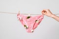 Woman hangs underwear with flowers on clothesline, concept content for feminist blog, poster about women`s health