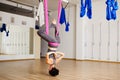 Woman hangs upside down doing aero anti gravity yoga exercises Royalty Free Stock Photo