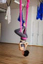 Woman hangs upside down doing aero anti gravity yoga exercises Royalty Free Stock Photo