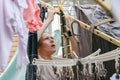 A woman hangs washed wet clothes after washing on a dryer in the yard Royalty Free Stock Photo