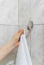 Woman hangs white bath towel on a hook Royalty Free Stock Photo