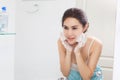 Woman happy cleanses the skin with foam in bathroom.