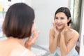 Woman happy cleanses the skin with foam on sink.