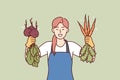 Woman is happy about good harvest of beets and carrots and demonstrates fresh vegetables