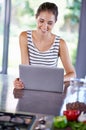 Woman, happy and laptop on kitchen counter, female person and home on internet. Google it, browsing cooking recipes and Royalty Free Stock Photo