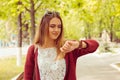 Woman happy smiling looking at wristwatch isolated on green park background Royalty Free Stock Photo