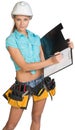 Woman in hard hat and tool belt writing on blank Royalty Free Stock Photo