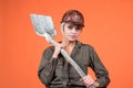 woman hard worker in protective helmet and boilersuit hold shovel on orange background, 1 may Royalty Free Stock Photo