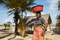 Woman has different goods in a bowl and carries it on her head traditionally.