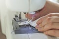 A woman has problems with her sewing problems. Close-up female hands pull out the bobbin thread